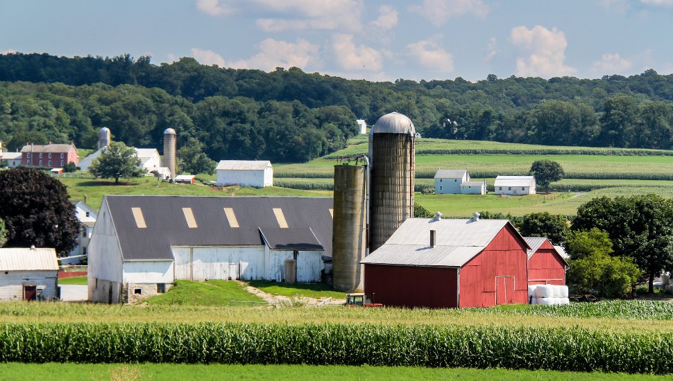 A farm with silo and barn out in the country.