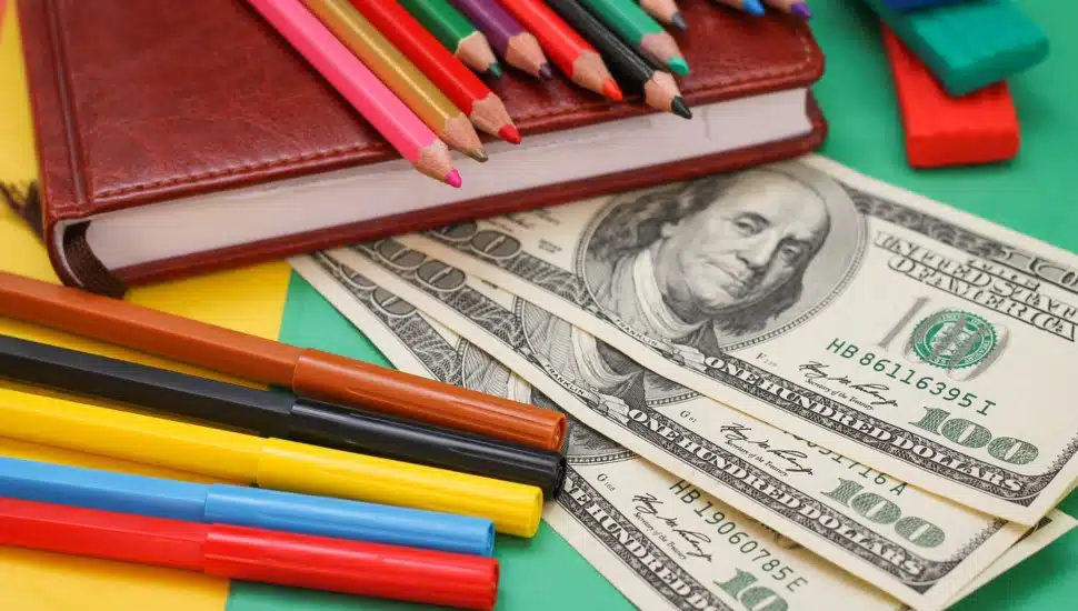 A book, colored pencils and a pile of cash.
