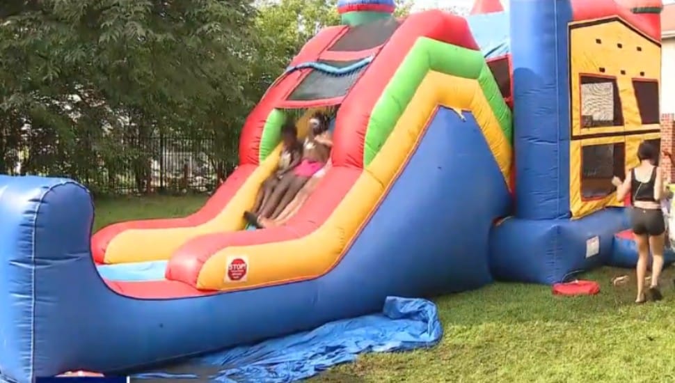 Kids go down a water slide at a recent Sunday Fun Day block party in Chester city.