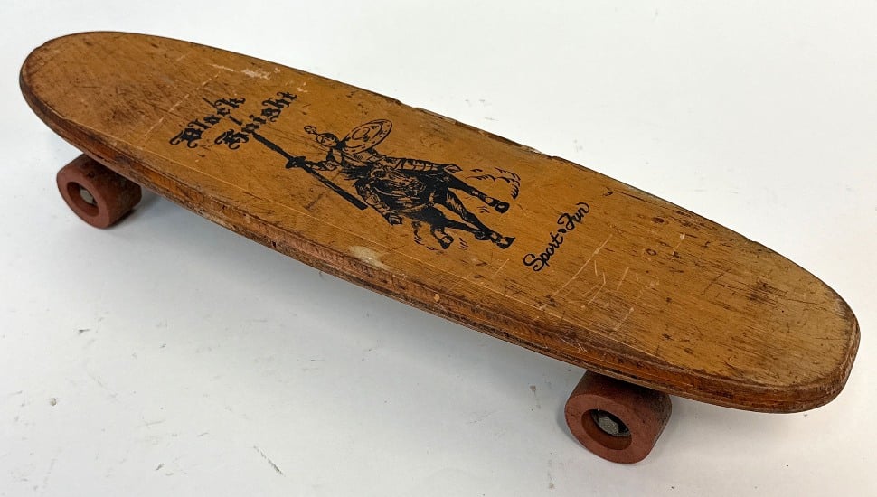 A vintage Sport Fun "Black Knight" wooden skateboard with clay wheels.