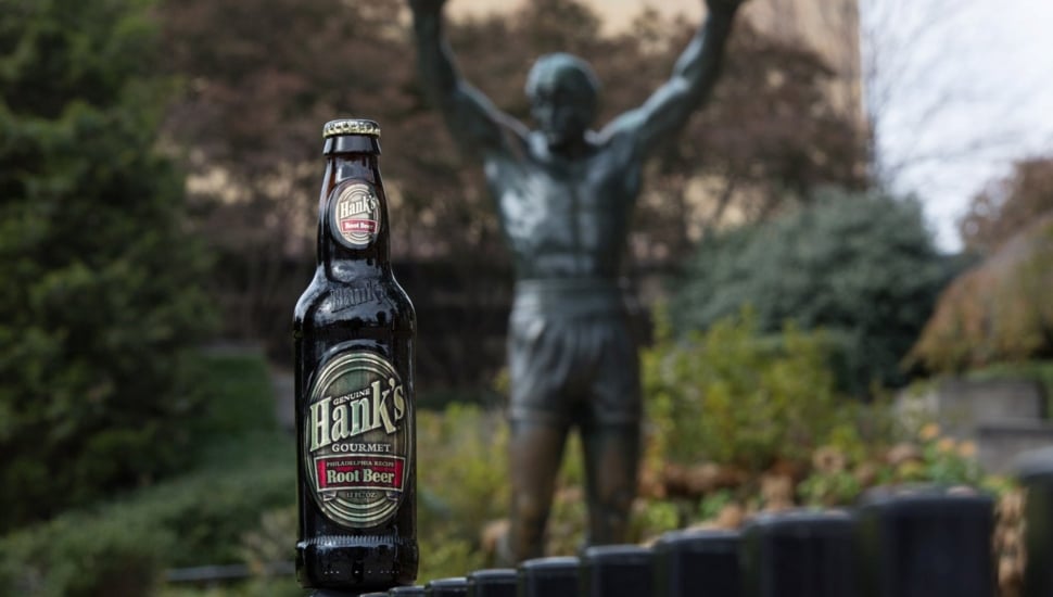 Soda bottle with Rocky statue in background.