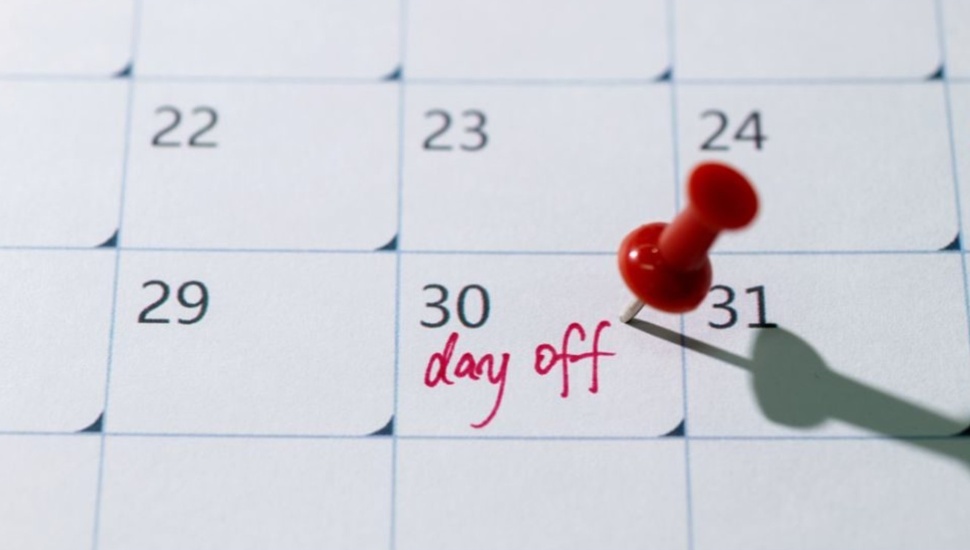 Calendar with red thumb tack on day off.