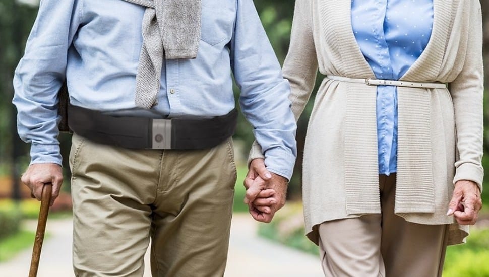 A man and woman walking together, each wearing a Tango belt.