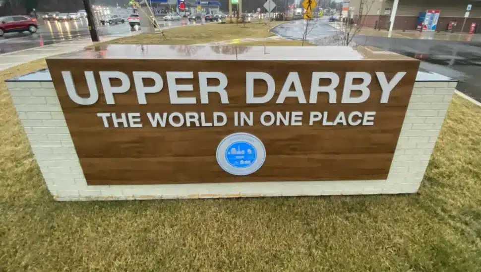 A sign at the Upper Darby Township border declaring Upper Darby as "The World in One Place."