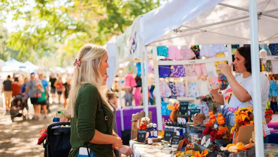 Two women check out a booth at last year’s arts and crafts festival at Linvilla Orhcards.