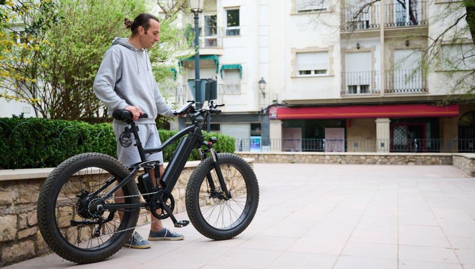A man stands next to his e-bike.