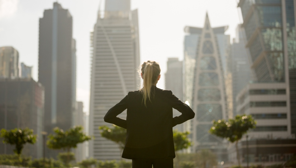 A businesswoman looks out into the city.