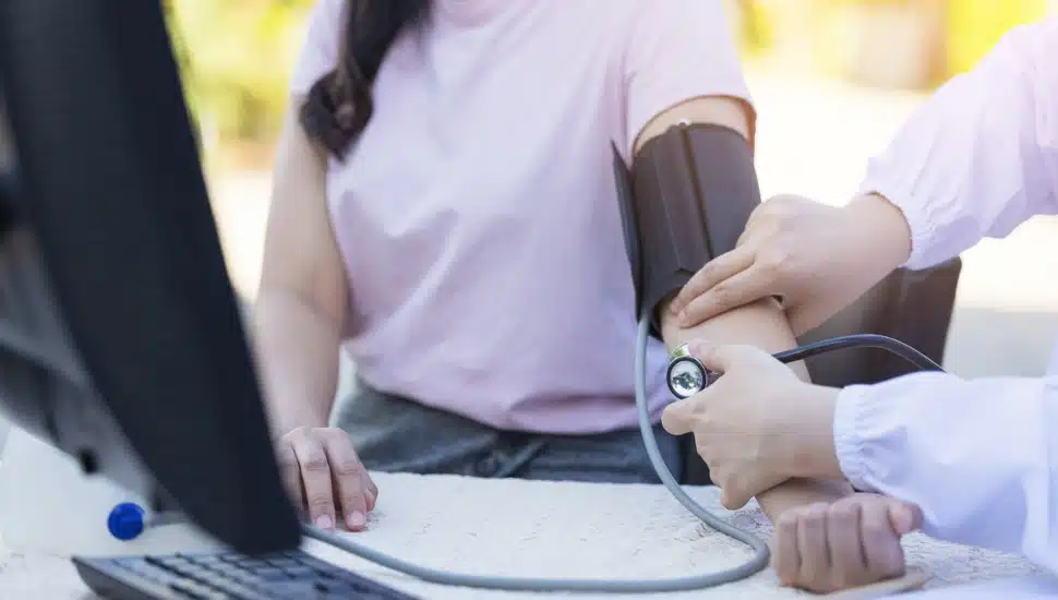 A girl has her blood pressure checked.