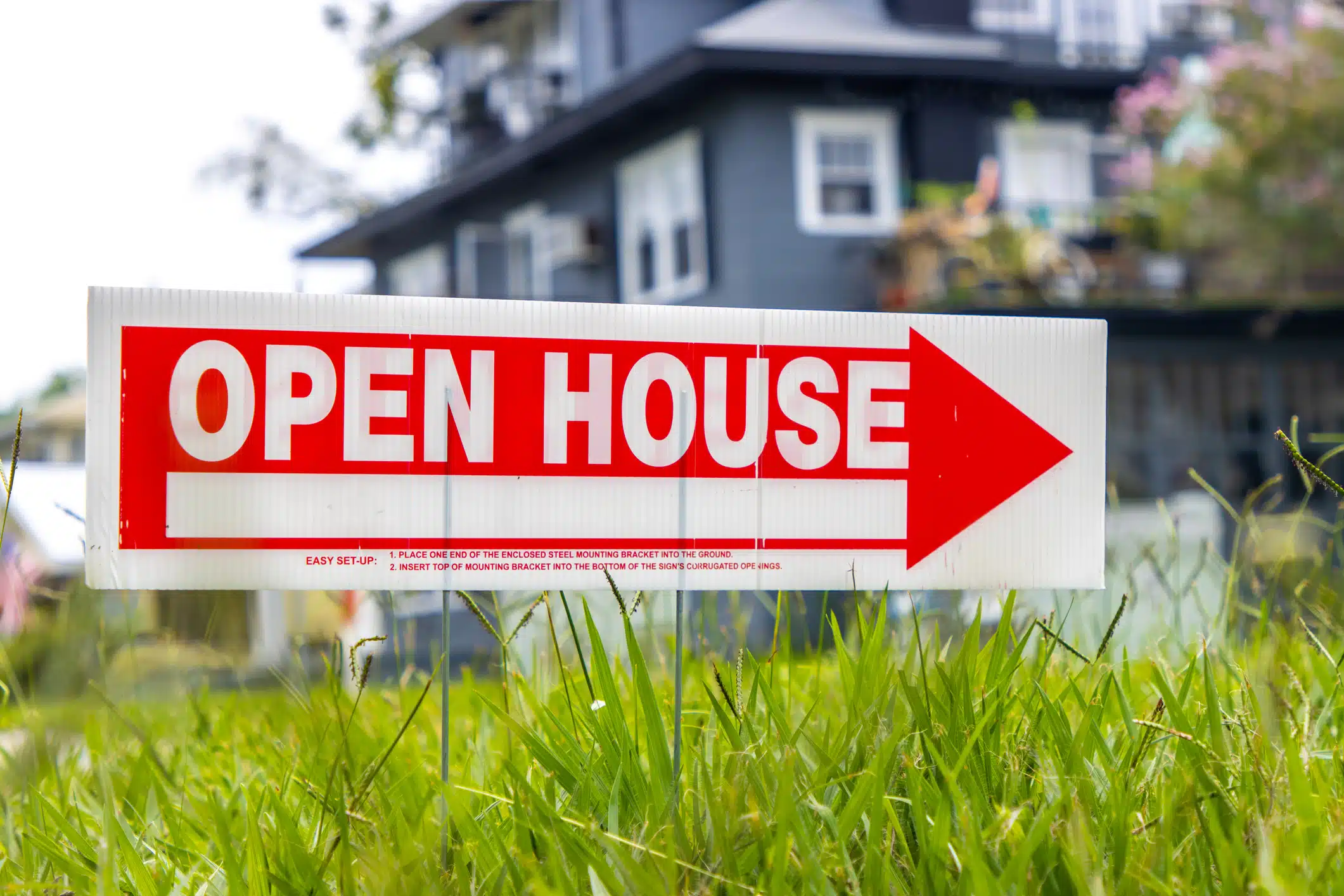 Open house sign on grass.