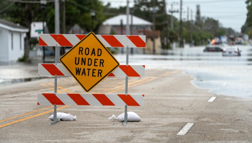 A sign on a street indicating the road ahead is underwater.