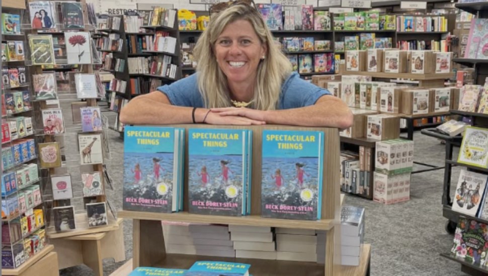 Beck-Dorey-Stein sitting in a bookstore behind copies of her new book.