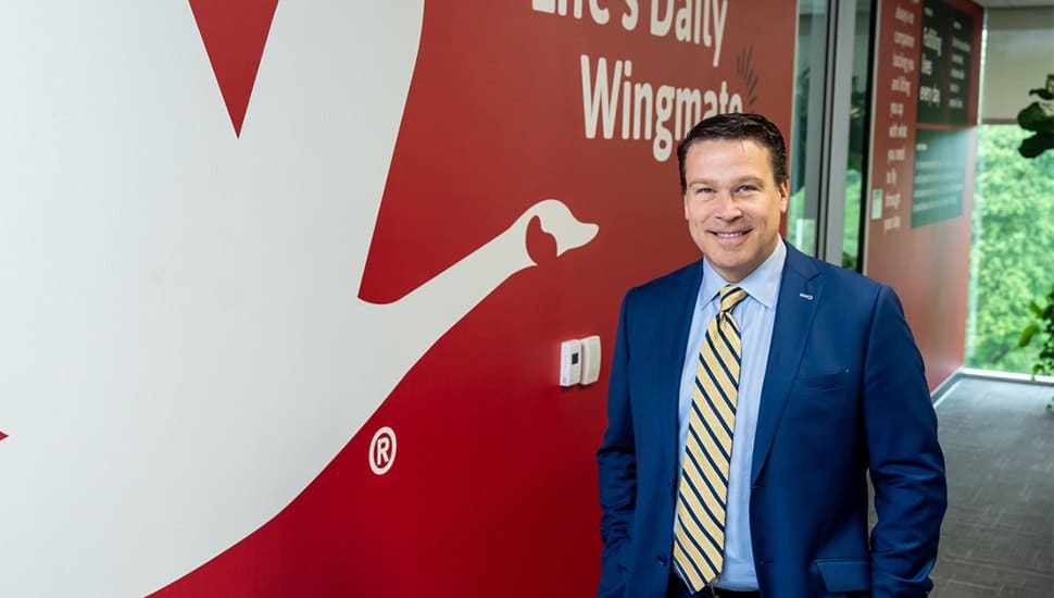 Brian Schaller standing next to the Wawa logo.