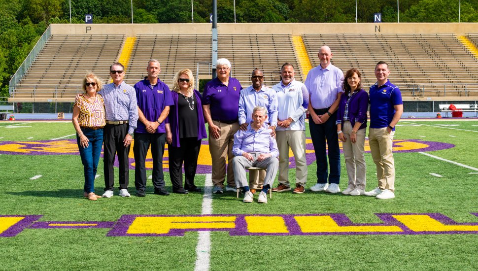 (L to R) Pictured on Tomlinson-Fillippo Field are Agnes Ware, Roger Ware ’82, Head Football Coach Duke Greco, West Chester University President Dr. Laurie Bernotsky, Robert “Tommy” Tomlinson ’70, Tom Fillippo ’69 (sitting), Vice President for University Advancement and External Affairs Dr. Zebulun Davenport, Vice President of University Affairs and Chief of Staff Andrew Lehman, Director of Athletics Terry Beattie, Executive Director of the West Chester University Foundation Deb Cornelius, and Interim President of Commonwealth University Dr. Jeffery Osgood, Jr. 