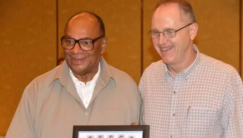 George Raveling with Chris "Sup Turner" Raveling is holding a team photo of the St. Denis CYO team that he coached in the 1960s.