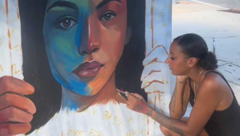 A woman works on a portrait.
