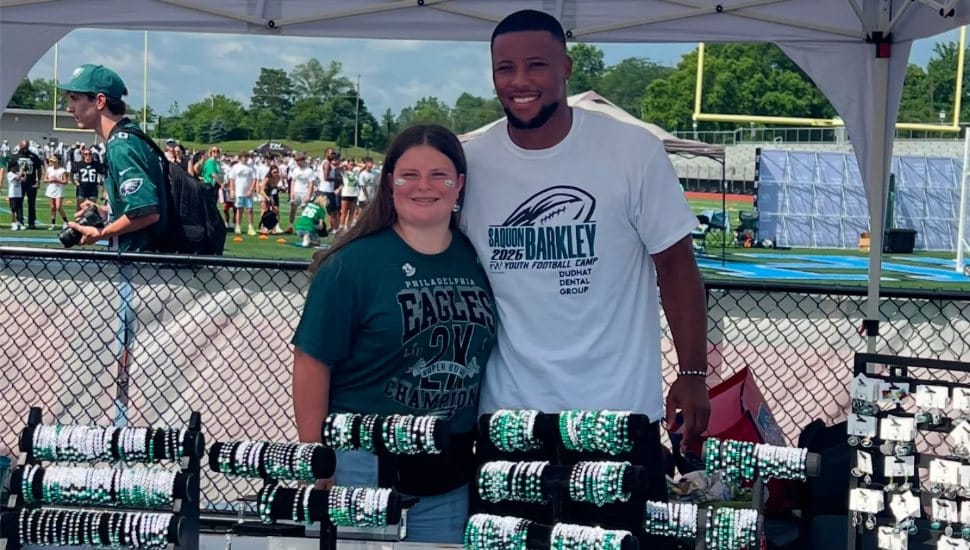 Exton teen Samantha Martin with Philadelphia Eagle Saquon Barkley at her jewelry business, Samantha's Beads.