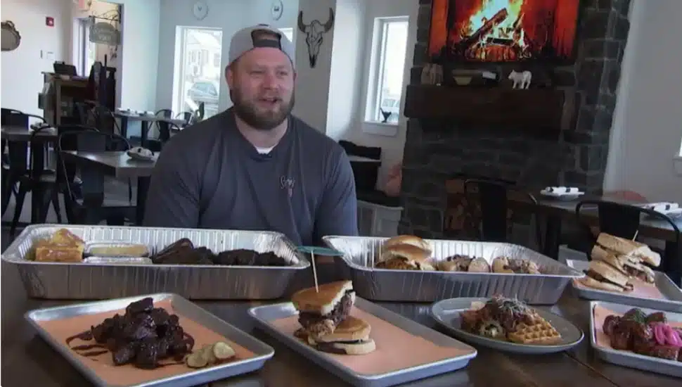Chef Greg Herman in front of some of the entrees available at Sophie’s BBQ in Havertown