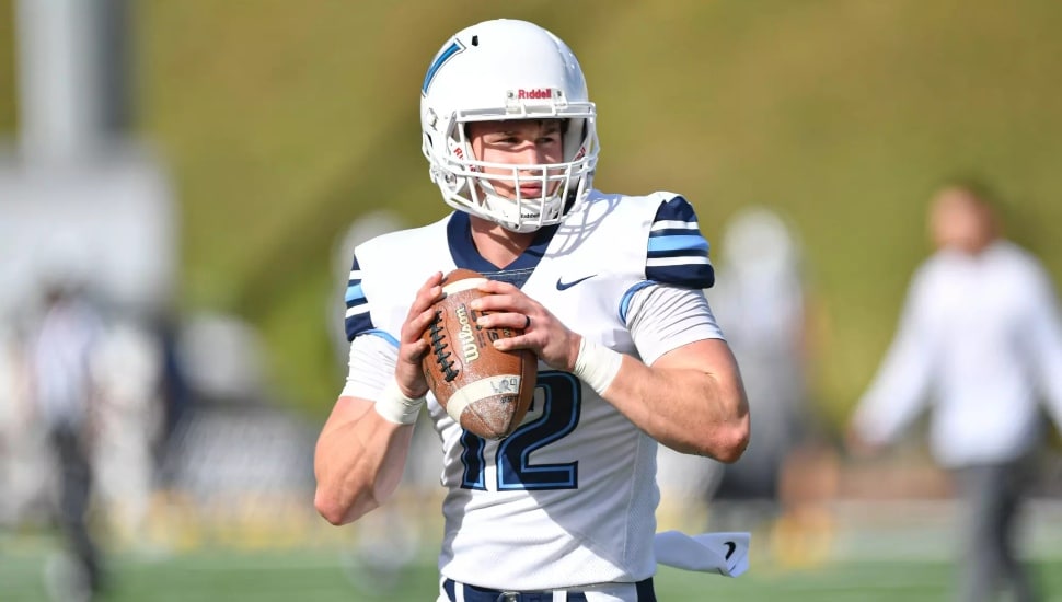 Tanner Maddocks in full Wildcats football gear on the field and ready to throw the football.