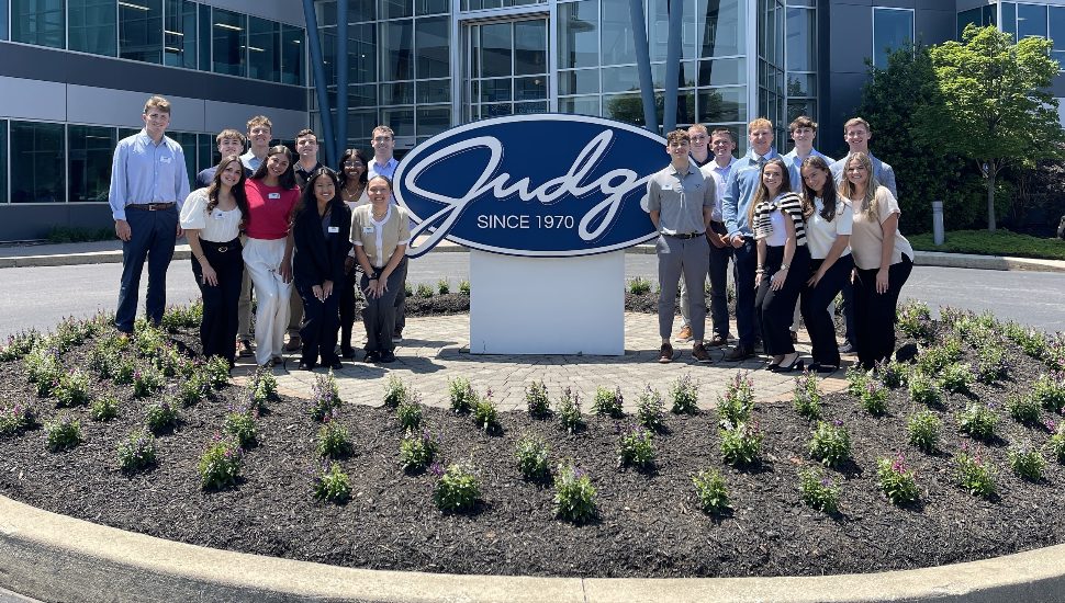 Interns with The Judge Group pose for an outdoor group photo.