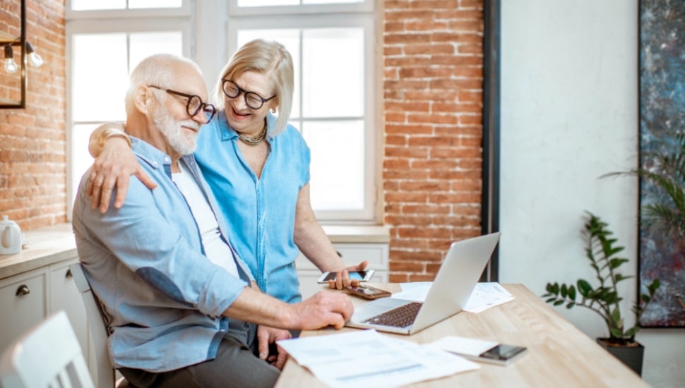 A senior couple happily sorting through their finances.