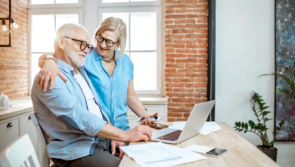 A senior couple happily sorting through their finances.