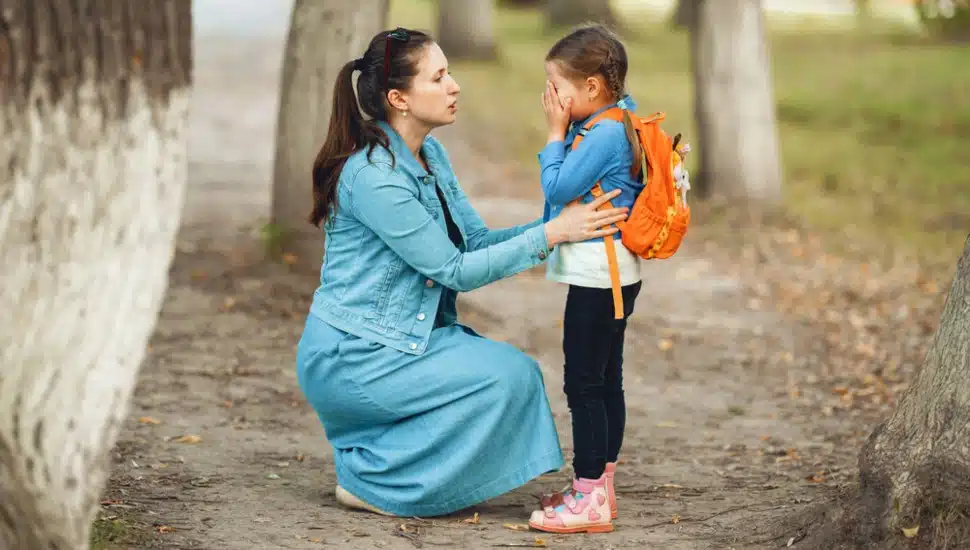A woman comforts a grieving young girl.
