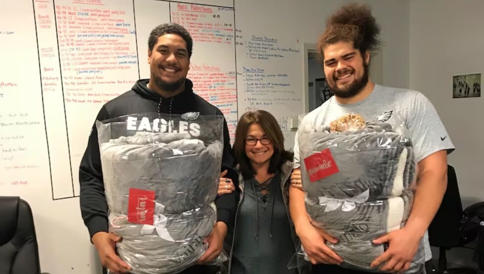 Halapoulivaati Vaitai and Isaac Seumalo with the Allison Stoutland’s gift blankets at the NovaCare Complex.