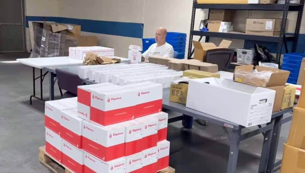 A man sits in an office at Baker Industries with several boxes nearby.