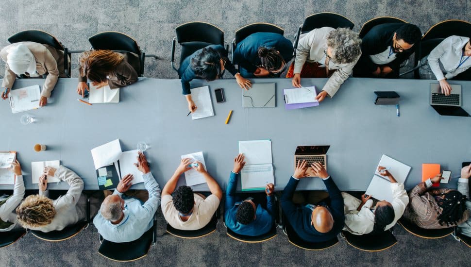 A look from above at a group of business people sitting around a conference table.