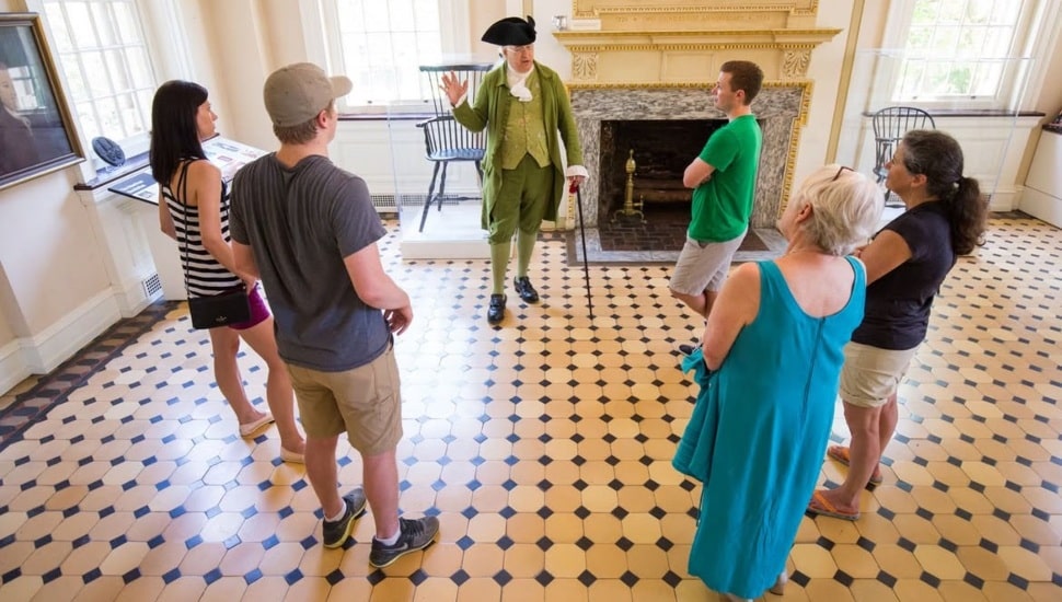 A guide in Colonial garb talks to tourists in Carpenter's Hall.