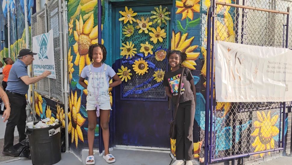 Intisar McNair and Ariane McClary with the sunflowers mural led by the Legacy Arts program, directed by Tucker Rodkey.