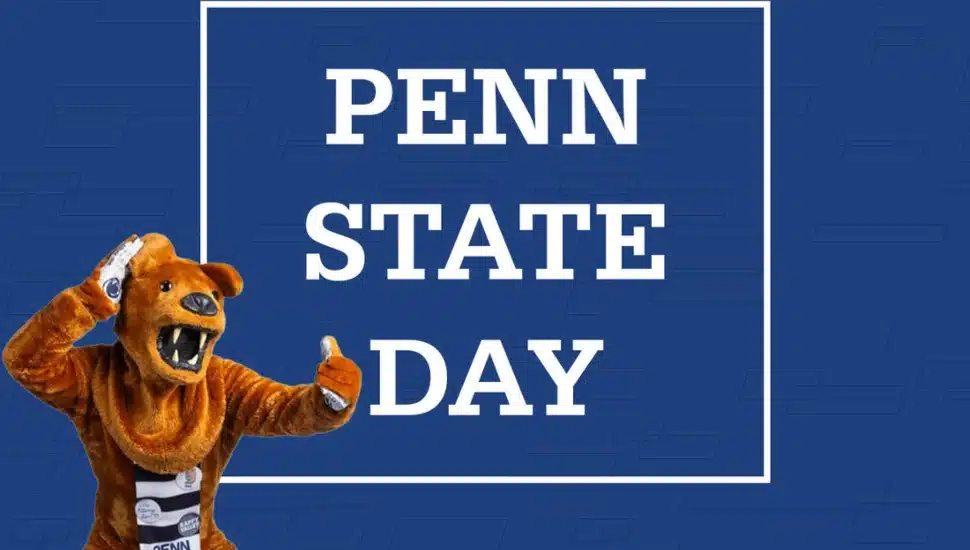 The Penn State Nittany Lion stands in front of the words Penn State Day.