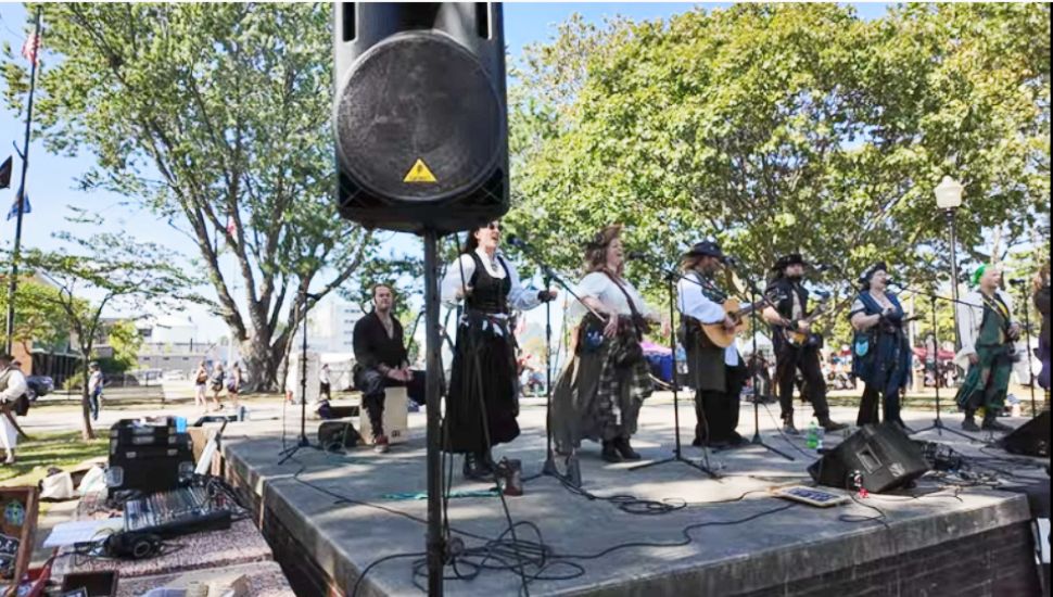 Performers on stage singing at the Marcus Hook Pirate Festival.