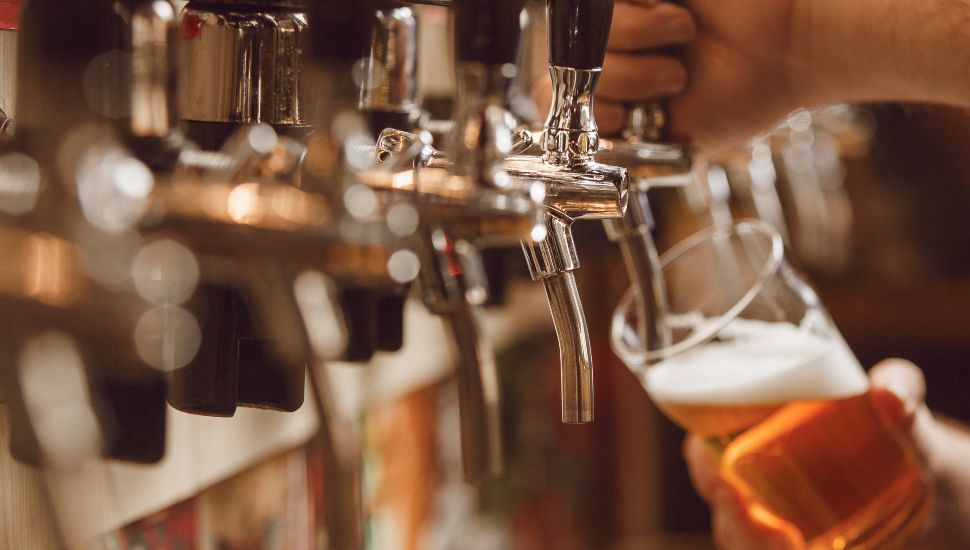 A beer mug filling up from a bar tap.