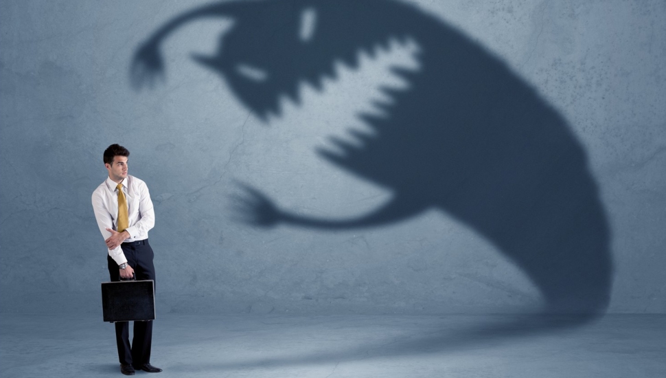 Businessman afraid of his own shadow monster.