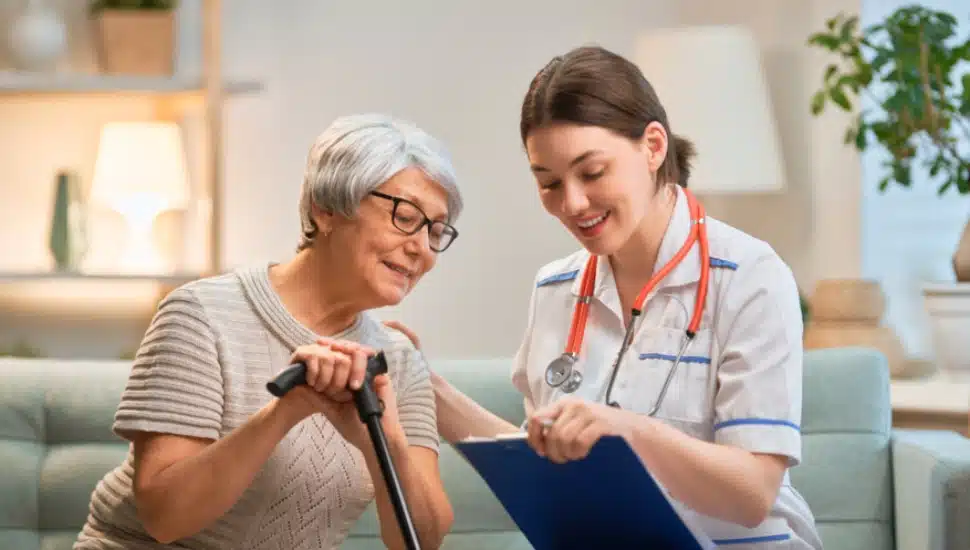 A female caregiver is spending quality time with a happy senior woman.