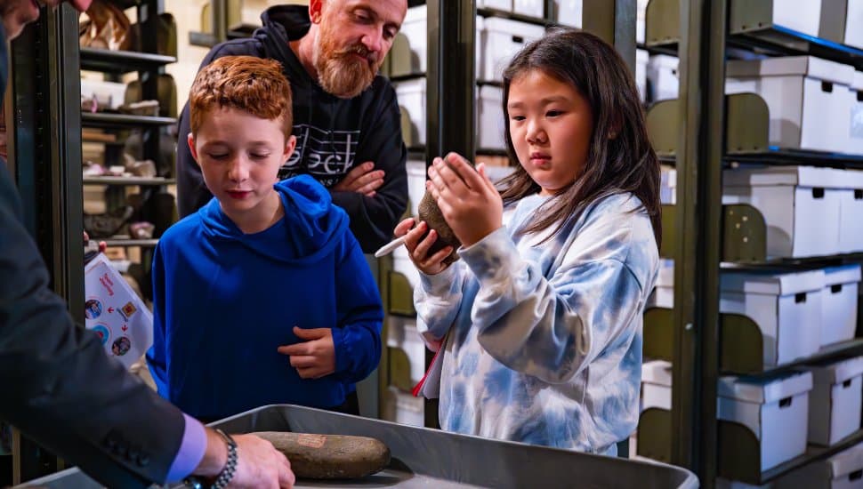 Children examine ancient artifacts during a visit to West Chester University’s Museum of Anthropology and Archaeology, part of the university’s collaboration with FIRST® LEGO® League teams exploring archaeology and robotics.