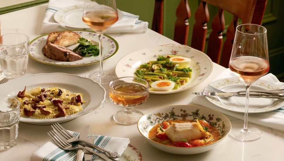 A table with several dishes of food at a restaurant.