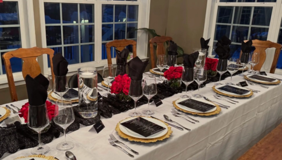 A formal table is set for a meal with wine glasses in view.