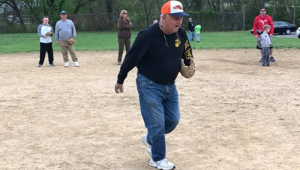 Longtime Challenger League Coach Jack Malone on the field with his players during a game.
