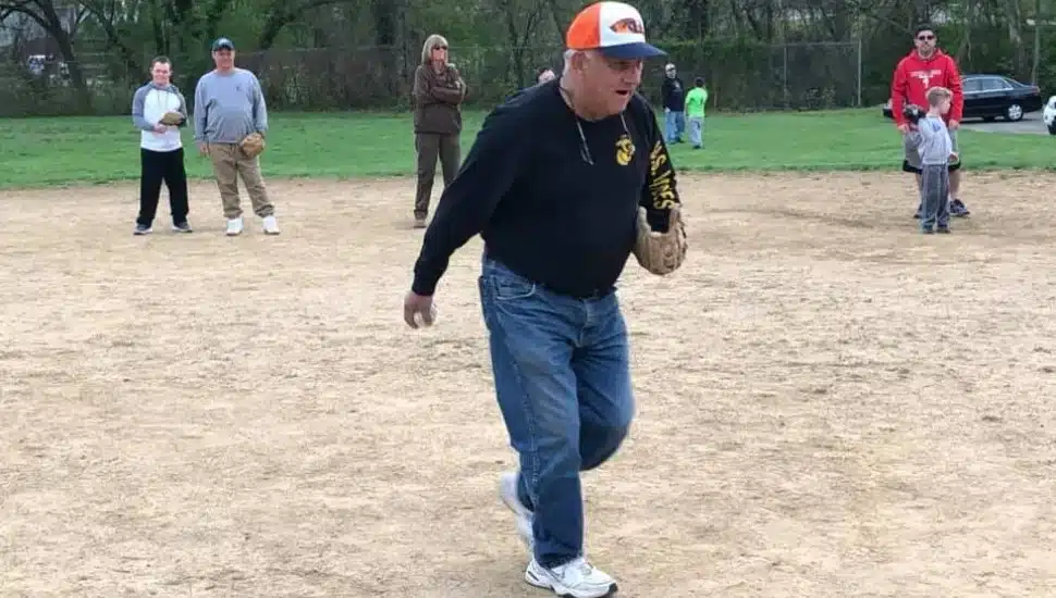 Longtime Challenger League Coach Jack Malone on the field with his players during a game.