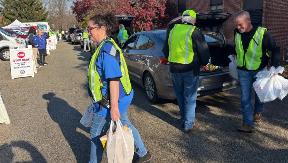 Volunteers remove food donations from vehicles at Saturday’s Delaware County Community Food Drive.