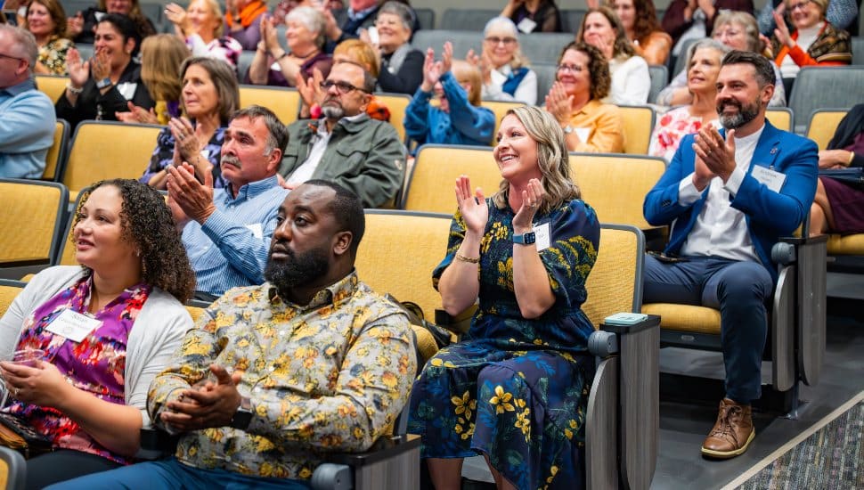 WCU nursing alumni, students, faculty, staff, and partners were thrilled with the surprise announcement that a School of Nursing within the College of Health Sciences will be a reality in January 2026. Photo of a happy audience clapping, smiling.