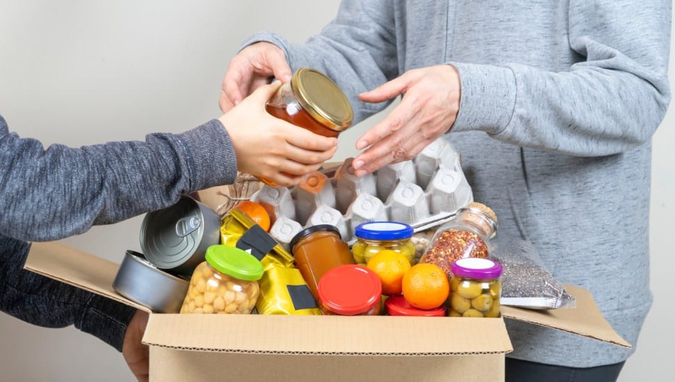 Volunteers fill of box with donated food.