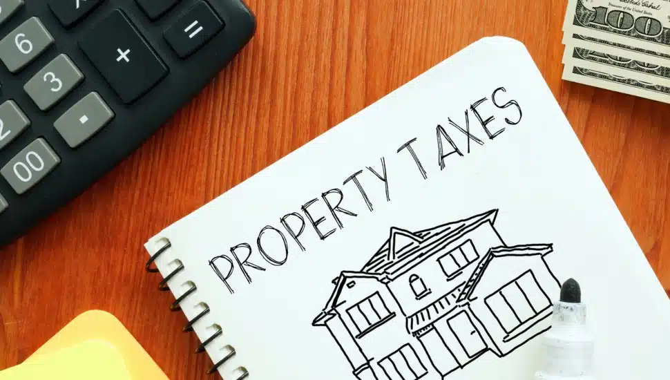 A notepad labeled "property taxes" with a calculator and post-it notes.