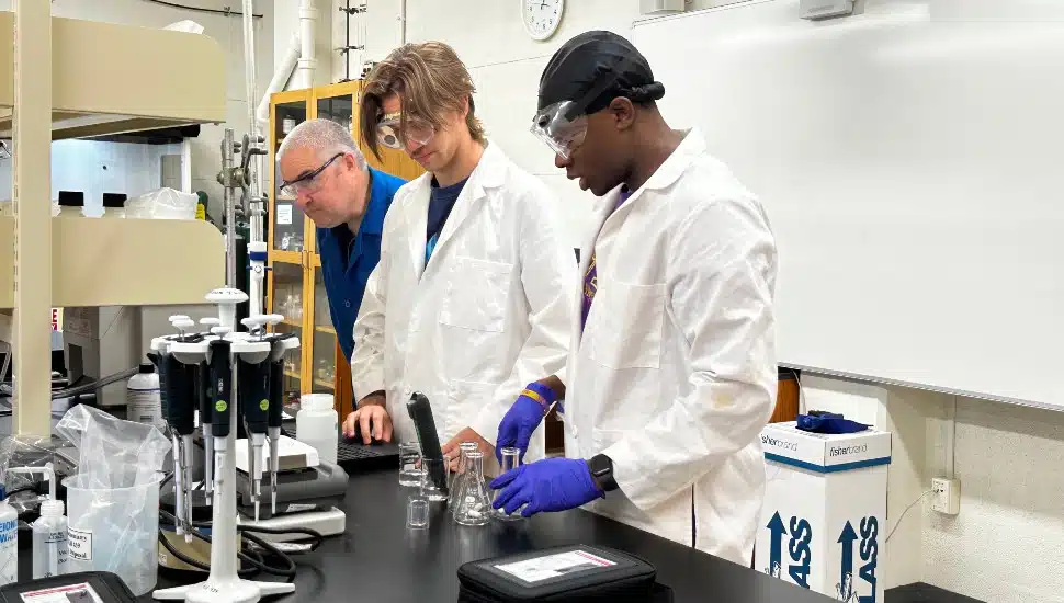Professor Domhnall OShaughessy (far left) and students David Young (left) and Jeremiah Valcourt (right) test samples in the lab.