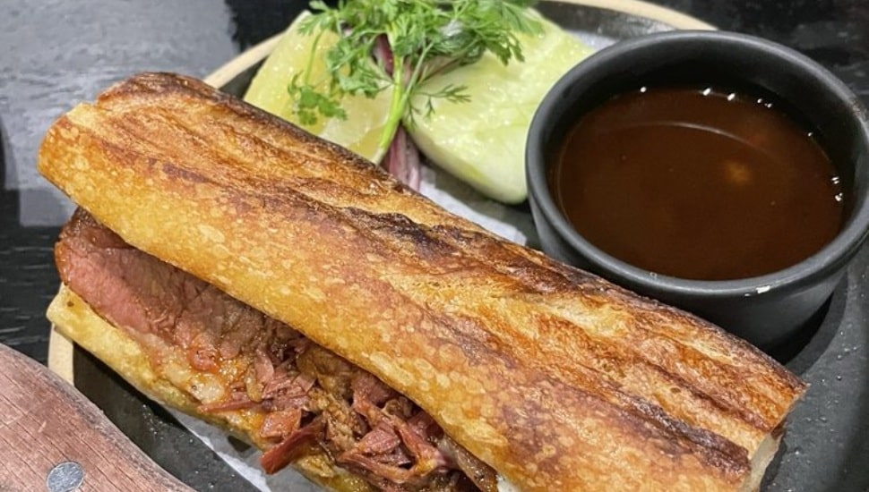A Barbacoa sandwich with sides.