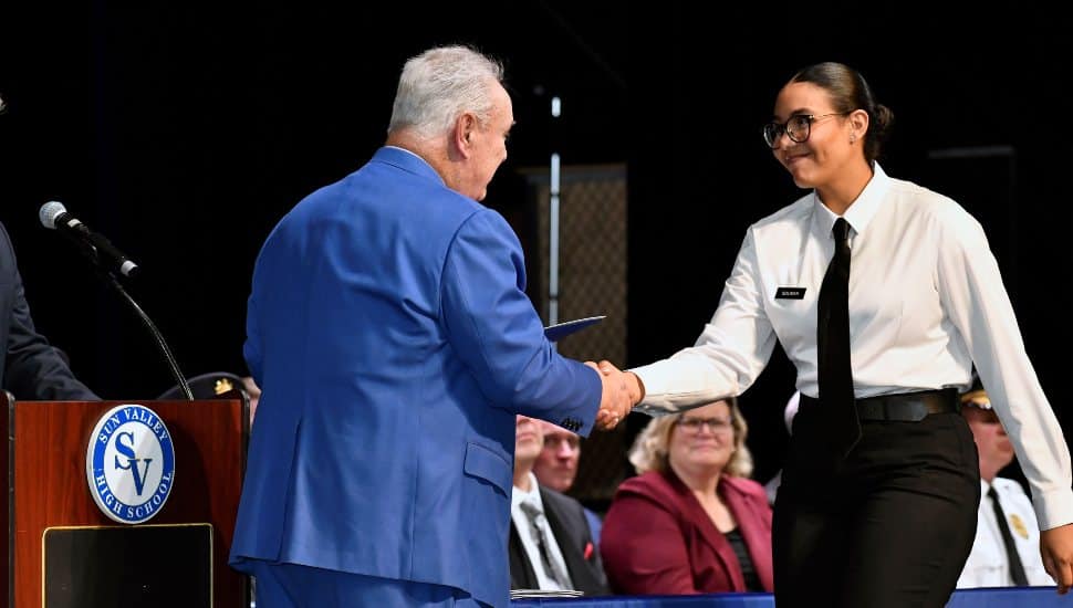 DCCC MPA Director William Davis congratulates graduating cadet Alaa Soliman. 