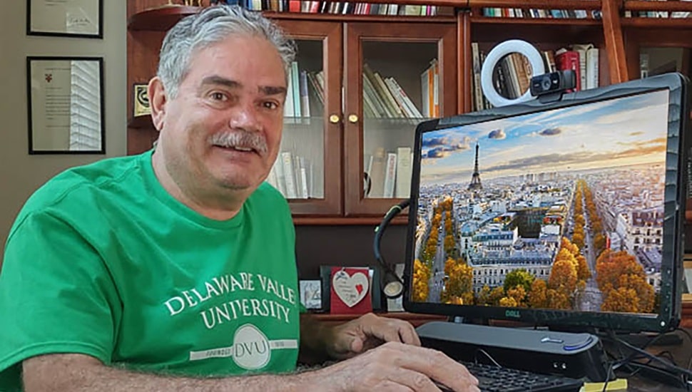 Retired man sits at computer.