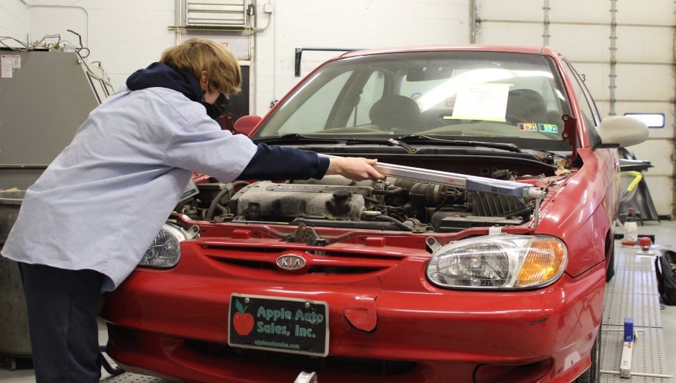 A student at the Delaware County Technical High School works on a vehicle.